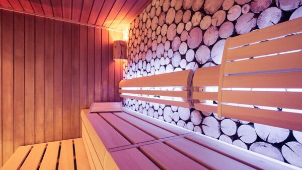 Sauna mit Holzbank und lila Lichtschein